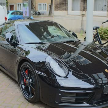 A black Porsche 911 detailed on an Amsterdam street.