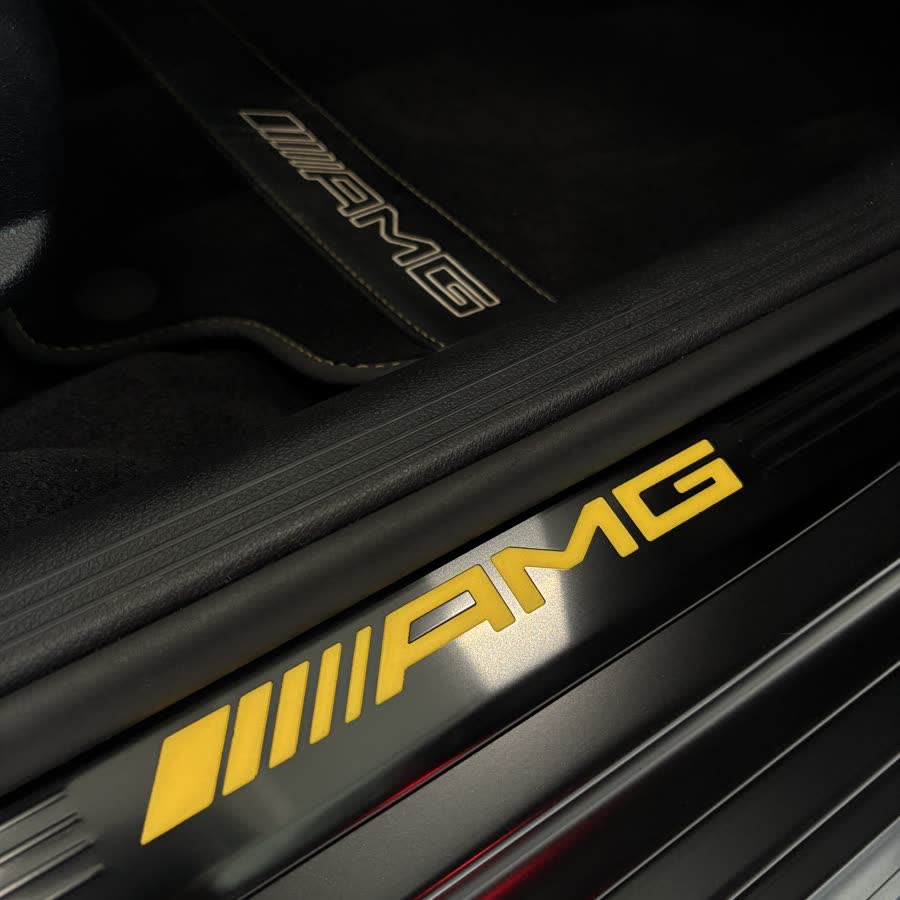 An illuminated AMG door sill after an interior detail.